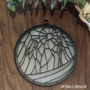 Puede incluir: Arte mural circular de metal con un dise&ntilde;o de vidriera. La obra de arte presenta una escena religiosa con figuras y un patr&oacute;n de sol. El texto "OPTION 3: CIRCULAR" est&aacute; en la parte inferior.