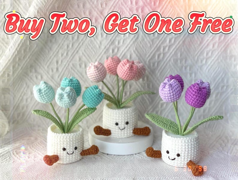 May include: Three crochet tulip plants in white pots with smiling faces and brown feet. The tulips are in shades of blue, pink, and purple. The text "Buy Two, Get One Free" is at the top of the image.