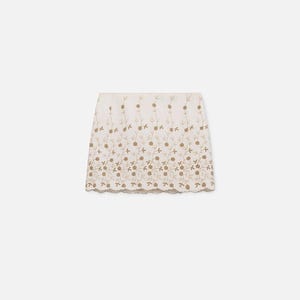 Puede incluir: Una falda color crema con intrincados bordados florales en un tono marr&oacute;n dorado. La falda presenta un dobladillo festoneado y un dise&ntilde;o delicado y femenino. El bordado crea un efecto texturizado, agregando inter&eacute;s visual a la prenda.