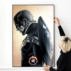K&ouml;nnte beinhalten: Eine Schwarzwei&szlig;illustration von Captain America, einem Superhelden, mit seinem Schild hinter ihm. Die Illustration ist auf einer Leinwand mit einem Gittermuster.