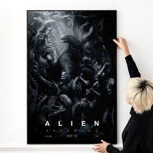 Puede incluir: Un póster en blanco y negro enmarcado con una ilustración oscura y detallada de criaturas de la película Alien. El póster muestra la palabra "ALIEN" en letras blancas, con "COVENANT" y "MAY 19" debajo.