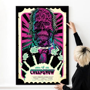 Puede incluir: Un póster enmarcado con una ilustración vibrante y perturbadora de una figura parecida a un zombi, con el título "Creepshow". La obra de arte está ambientada sobre un fondo rosa y negro, enmarcada por un borde de estilo sello vintage. El póster se está colgando.