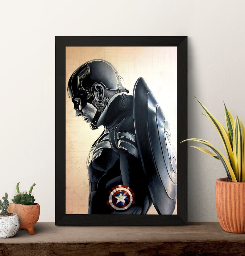K&ouml;nnte beinhalten: Eine Schwarzwei&szlig;illustration von Captain America in einer Superheldenpose. Er tr&auml;gt einen blauen und roten Anzug mit einem Stern auf der Brust. Er h&auml;lt einen Schild in seiner rechten Hand. Die Illustration ist in einem schwarzen Rahmen gerahmt.