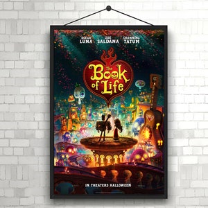 May include: A movie poster for "The Book of Life" featuring a red heart with the title in white text. The poster has a colorful background with a cityscape and characters from the movie. The poster also includes the names of the actors: Diego Luna, Zoe Saldana, and Channing Tatum. The text "In Theaters Halloween" is at the bottom of the poster.