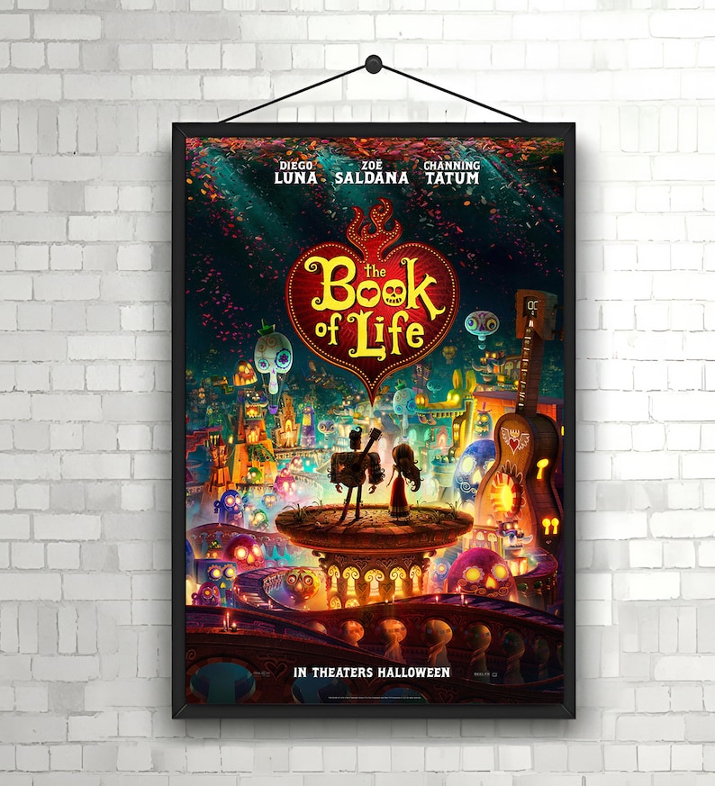 May include: A movie poster for "The Book of Life" featuring a red heart with the title in white text. The poster has a colorful background with a cityscape and characters from the movie. The poster also includes the names of the actors: Diego Luna, Zoe Saldana, and Channing Tatum. The text "In Theaters Halloween" is at the bottom of the poster.