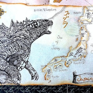 以下が含まれることがあります： 左上の隅にゴジラの白黒イラストが描かれた、手書きの日本の地図。地図には、北海道、本州、四国、九州の島々が示されている。日本海と太平洋がラベル付けされている。地図は羊皮紙のような背景に描かれている。