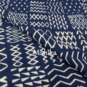 Może przedstawiać: Niebieski materiał z białym geometrycznym wzorem. Materiał jest złożony na pół, a wzór jest widoczny po obu stronach. Tekst "Mishika" jest widoczny w prawym dolnym rogu obrazu.