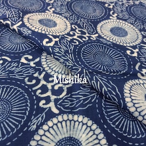 May include: Indigo blue fabric with a white floral pattern. The fabric features a repeating design of stylised flowers and leaves. The fabric is folded in half, and the word "Mshika" is visible in the centre of the image.