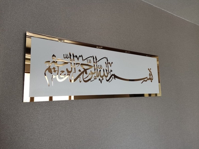 Op de afbeelding: Een gouden lijst met een witte achtergrond met gouden Arabische kalligrafie. De kalligrafie luidt "Allah" en "Muhammad".