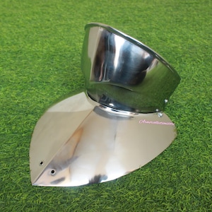 Könnte beinhalten: Ein silberner Nackenschutz aus Metall für einen Helm mit abgerundeter Oberseite und spitzer Unterseite. Der Schutz ist so konzipiert, dass er Nacken und Schultern vor Schlägen schützt.