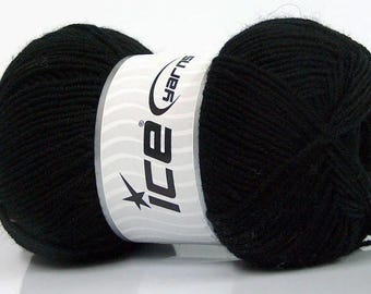 Puede incluir: Una madeja de hilo negro sólido envuelta en una etiqueta de papel blanco con el texto Ice Yarns y un gráfico de estrella. El hilo está enrollado en una forma de bola densa y redondeada con una textura de fibra retorcida visible en todo el material.