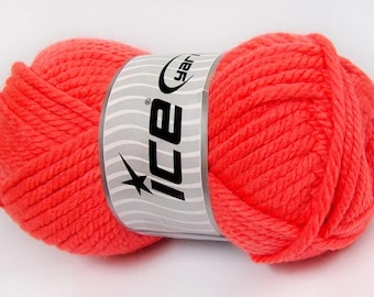 May include: A skein of bright neon coral yarn wrapped in a white paper label. The label features a wavy gray pattern and the black text "ice yarn" with a star icon. The yarn has a thick, twisted texture and is presented as a single, rounded unit.