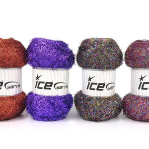 May include: Four skeins of fuzzy, metallic yarn arranged in a row. Each skein features a white paper label with the text 'ice yarns' and a star logo. The yarn colors from left to right are copper, vibrant purple, a dark multi-color, and a magenta multi-color.