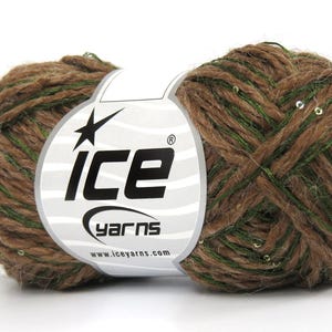 May include: A ball of brown and green yarn featuring small, reflective silver sequins throughout the fibers. A white paper label wraps around the center, displaying the black text 'ice yarns' and the website address 'www.iceyarns.com'.