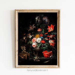 Puede incluir: Una pintura al óleo enmarcada que representa una naturaleza muerta con un jarrón de flores de colores, incluyendo tulipanes rojos, rosas blancas y claveles rosas. Un pequeño gato asoma por detrás del jarrón, y un objeto de madera se encuentra en primer plano.