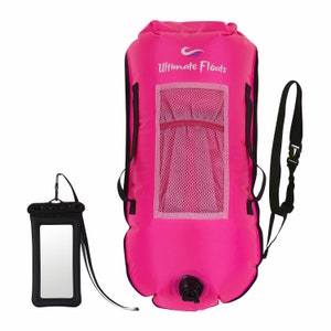 Könnte beinhalten: Eine rosa aufblasbare Trockenbeutel mit einem Netzfach und einem schwarzen Gurt. Auf der Tasche steht "Ultimate Floats". Ein schwarzer wasserdichter Handybeutel mit einem Gurt ist ebenfalls enthalten.
