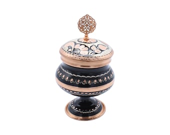 Peut inclure: Un sucrier noir et cuivre avec un couvercle décoratif et un motif floral. Le bol a une base ronde et un piédestal.