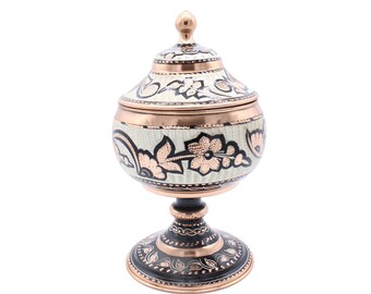 Peut inclure: Un bol à sucre en cuivre décoratif avec un couvercle et un piédestal. Le bol est décoré de motifs floraux noirs et blancs et a une finition en cuivre.
