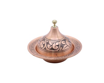 Peut inclure: Un bol à sucre en cuivre avec un couvercle et un motif floral décoratif. Le bol a une base ronde et un couvercle bombé avec un petit bouton sur le dessus.