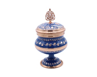 Peut inclure: Un sucrier bleu et cuivre avec un couvercle décoratif et un motif floral. Le bol est sur un piédestal.