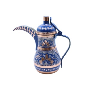 May include: A blue and copper Turkish coffee pot with intricate floral designs. The pot has a curved spout and a handle.