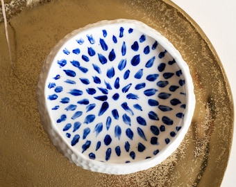 Ceramic bowl made of white clay with carving and painted with dark blue paint.