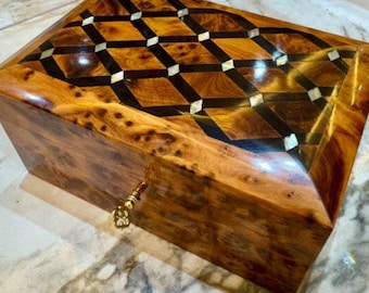 Handcrafted wooden box with intricate geometric inlay design,glossy finish, and a small golden key.Perfect for storing jewelry or keepsakes.