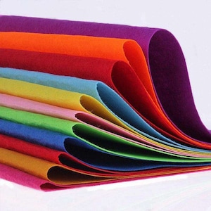 Könnte beinhalten: Ein Stapel bunter Filzstoffbögen in verschiedenen Farbtönen von Lila, Orange, Rot, Blau, Grün, Gelb und Rosa. Die Bögen sind fächerförmig angeordnet, wobei der lila Bogen oben und der rosa Bogen unten liegt.
