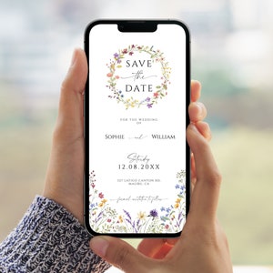 Puede incluir: Una tarjeta digital de guardar la fecha con un diseño de corona floral. El texto dice "Save the Date" con una corona floral que rodea el texto. El texto debajo de la corona dice "For the Wedding of Sophie and William, Saturday 12.08.20XX, 127 Latigo Canton Rd, Malibu CA".