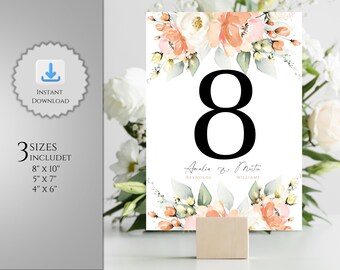 May include: Peach and white floral wedding table number card with the number 8 and the names Amalie & Martin with their last names Reynolds and Williams. The card is 8 inches by 10 inches.