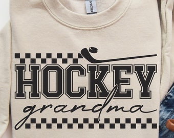 May include: A beige sweatshirt with a black and white checkered design and the text "HOCKEY grandma".