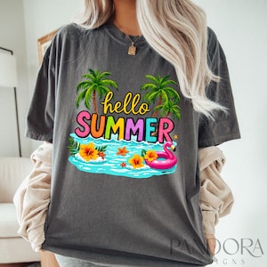 May include: A gray t-shirt with a graphic design of palm trees, a pool, a flamingo float, and the text "hello summer".