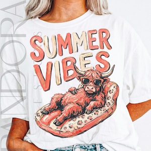 Może przedstawiać: Biała koszulka z napisem "SUMMER VIBES" w koralowych i beżowych literach. Kreskówkowa krowa Highland w okularach przeciwsłonecznych wyleguje się na czerwonym i lampartowym materacu. Koszulka w stylu casual na lato.