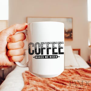 May include: White ceramic coffee mug with black text that reads "Coffee Makes Me Nicer."