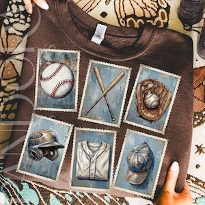 This brown T-shirt features a vintage baseball stamp-style grid design with a crochet yarn texture. The design incorporates traditional baseball motifs such as a baseball, crossed bats, a glove holding a ball, a helmet, a jersey and a cap. Each image appears to be hand-stitched, with visible yarn details in warm brown, tan, cream and muted blue tones, creating a cosy, retro sports look.