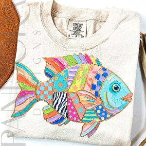 A colorful tropical fish is decorated with bright patchwork patterns including stars, stripes, dots, and checkered sections in pink, blue, green, yellow, and purple tones. The design has a playful coastal summer style with bold painted textures.