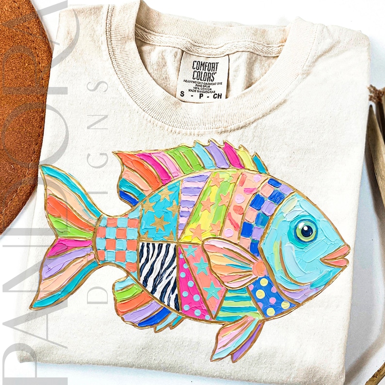 A colorful tropical fish is decorated with bright patchwork patterns including stars, stripes, dots, and checkered sections in pink, blue, green, yellow, and purple tones. The design has a playful coastal summer style with bold painted textures.