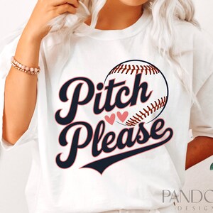 K&ouml;nnte beinhalten: Wei&szlig;es T-Shirt mit einem Baseball-Motiv und dem Text "Pitch Please" in Marineblau und Rosa.