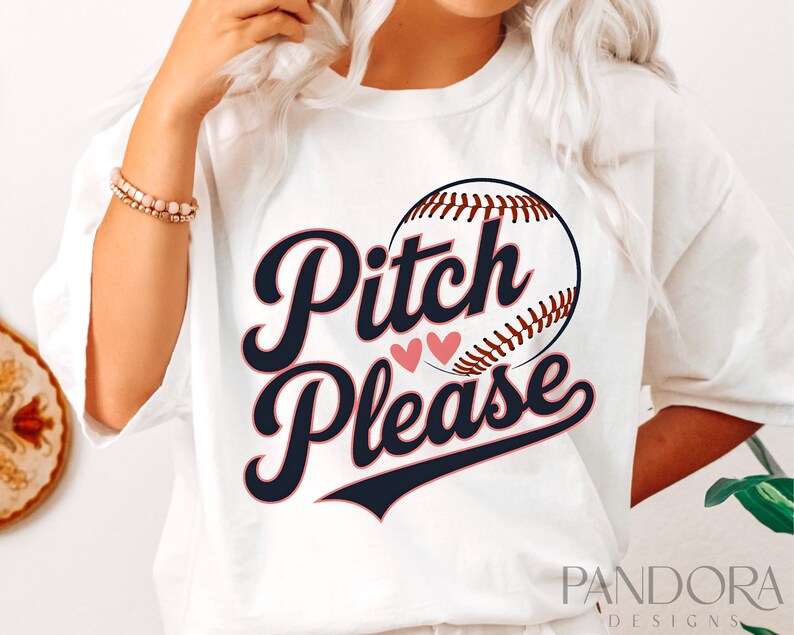K&ouml;nnte beinhalten: Wei&szlig;es T-Shirt mit einem Baseball-Motiv und dem Text "Pitch Please" in Marineblau und Rosa.