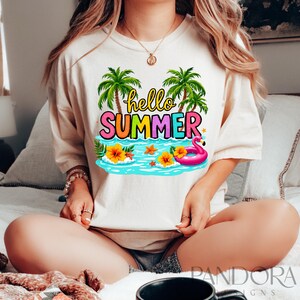 May include: A white t-shirt with a colorful graphic design featuring palm trees, a flamingo float, and the text "hello summer".