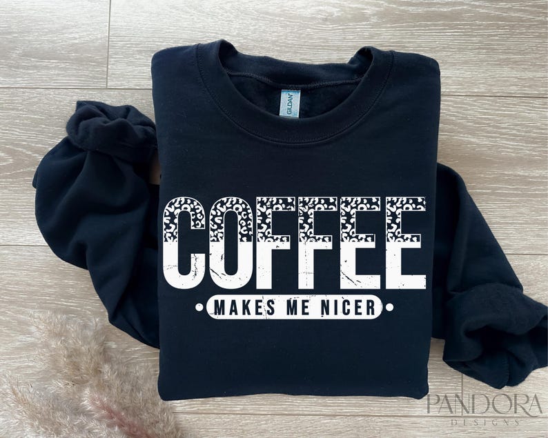May include: Black sweatshirt with white text that reads "Coffee Makes Me Nicer" with a leopard print design.