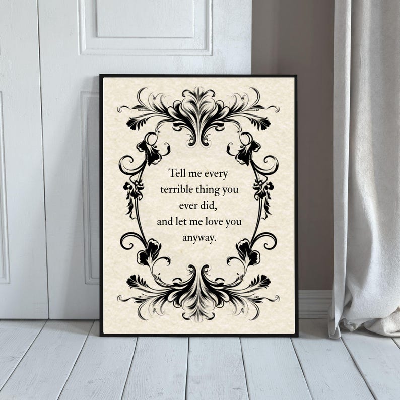 May include: A rectangular wall art print featuring a cream-colored background with a black ornate filigree border. The text in the center reads: Tell me every terrible thing you ever did, and let me love you anyway. The print is in a black frame.