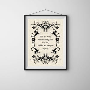 May include: A framed wall art print featuring a cream-colored background with a black ornate floral border. The text in the center reads: Tell me every terrible thing you ever did, and let me love you anyway. The frame is black with a hanging wire.