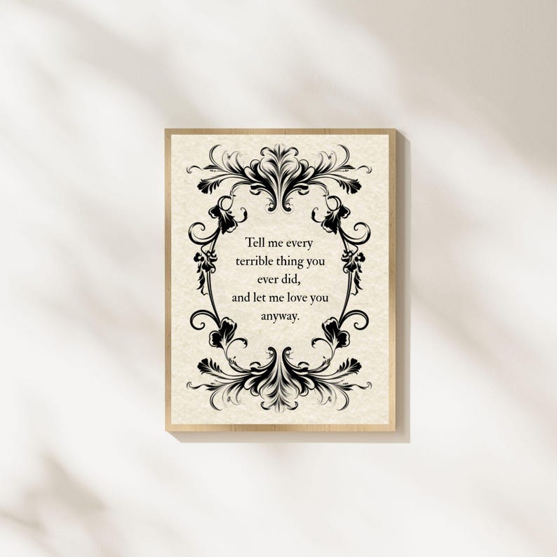 May include: A rectangular wall art print featuring a cream-colored background with a black ornate floral border. The center text reads: Tell me every terrible thing you ever did, and let me love you anyway. The print is framed in a light wood frame.