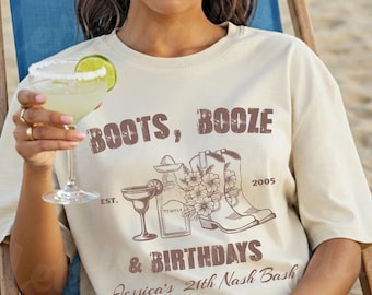 May include: Cream-colored t-shirt with the text "BOOTS, BOOZE & BIRTHDAYS" and a graphic of a margarita, tequila bottle, and cowboy boots. The shirt also includes the text "Jessica's 21th Nash Bash" and the year "2005".