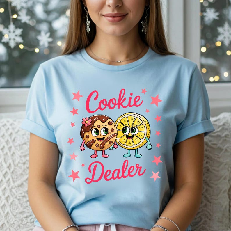 Sweatshirt featuring a cute cartoon cookie and lemon characters holding hands with the text “Cookie Dealer,” shown in a playful, colorful design; the design is available on t-shirts and sweatshirts in multiple sizes and a variety of colors.