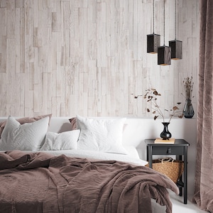 Könnte beinhalten: Ein Schlafzimmer mit einem braunen Bettbezug auf einem Bett mit weißen Kissen. Hinter dem Bett befindet sich eine Holzwand und ein schwarzer Nachttisch mit einer Vase mit Trockenblumen und einem Weidenkorb darauf. Drei schwarze Pendelleuchten hängen von der Decke.