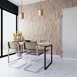 Puede incluir: Un comedor con una pared de madera, una puerta blanca y una mesa con cuatro sillas. La mesa es de madera y las sillas son de metal con asientos tejidos. Hay dos lámparas colgantes que cuelgan del techo.