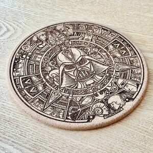 Peut inclure: Un dessous de verre rond en liège avec un motif gravé au laser détaillé représentant Dark Vador de Star Wars. Le motif comprend d'autres personnages et symboles de l'univers Star Wars.
