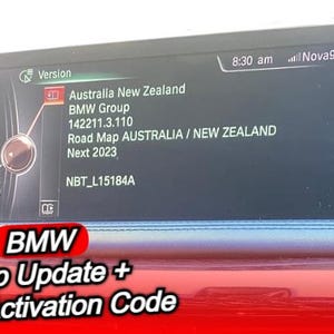 May include: A car's dashboard screen displays map update information for Australia and New Zealand. The screen shows the BMW Group, version details, and the text "Road Map AUSTRALIA / NEW ZEALAND Next 2023." The bottom of the screen reads "BMW Map Update + FSC Activation Code."
